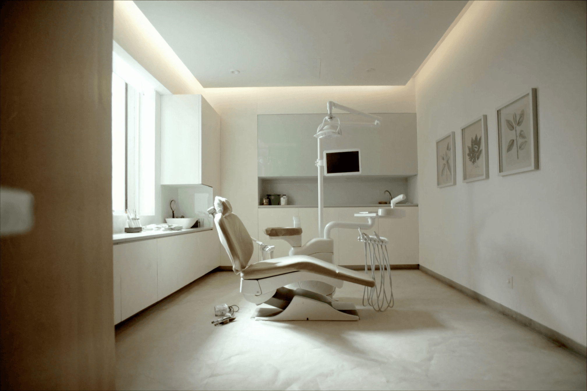 Calm treatment room with a modern dental chair beside a bright window